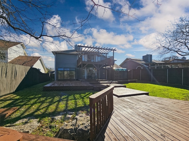 rear view of house featuring a wooden deck, a lawn, and a pergola