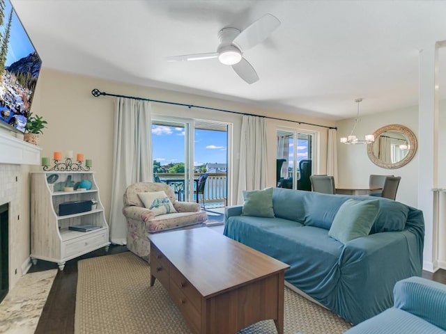 living room with ceiling fan with notable chandelier, hardwood / wood-style flooring, and a water view