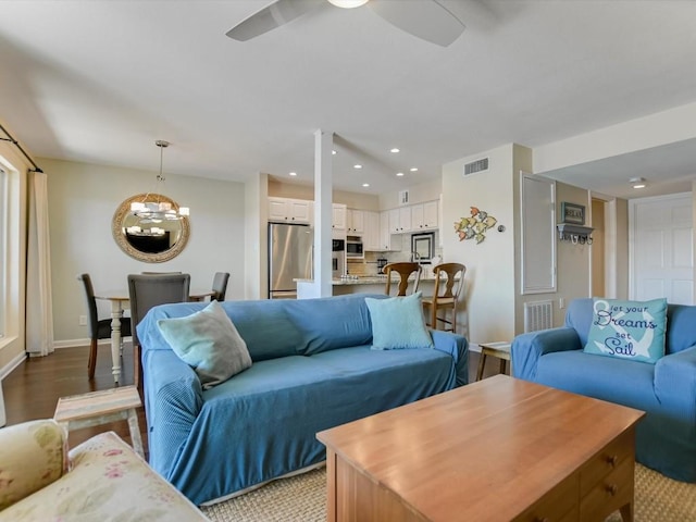 living room featuring ceiling fan with notable chandelier