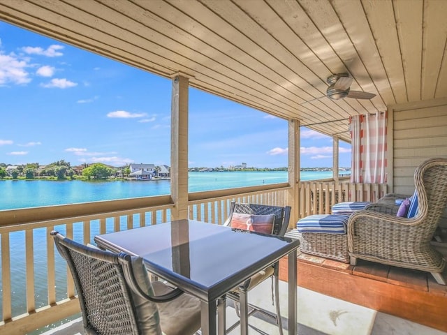 wooden deck with ceiling fan and a water view