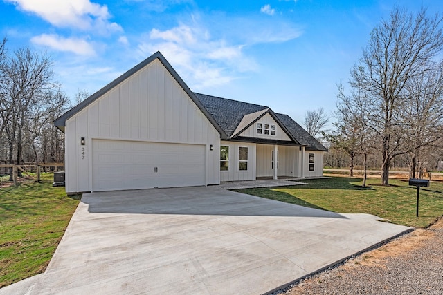 view of front of house with covered porch, a garage, and a front lawn