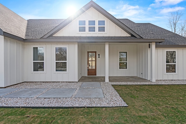 view of exterior entry featuring a patio area and a yard