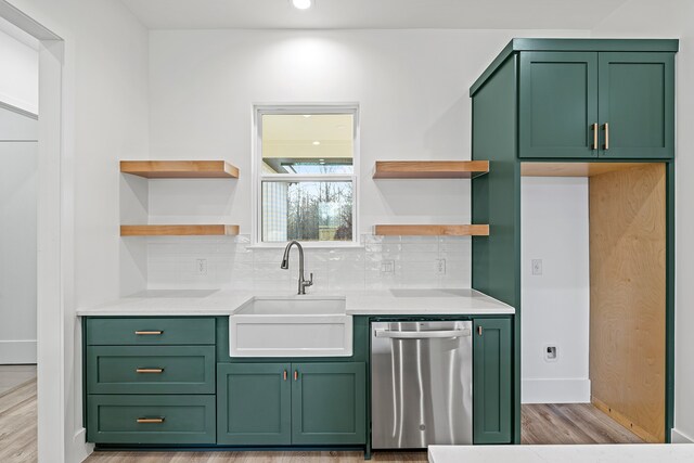 kitchen with dishwasher, light hardwood / wood-style floors, green cabinets, and sink