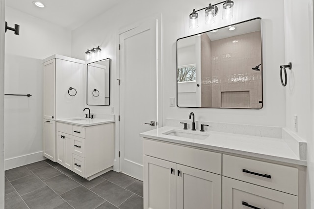 bathroom with a tile shower, tile patterned flooring, and vanity