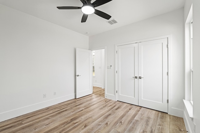 unfurnished bedroom featuring light wood-type flooring, a closet, and ceiling fan