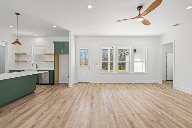 unfurnished living room with ceiling fan, sink, and light hardwood / wood-style flooring