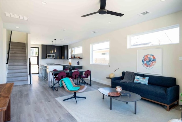 living room with ceiling fan and light hardwood / wood-style floors