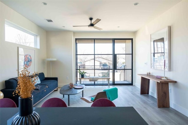 living room featuring ceiling fan and light hardwood / wood-style floors