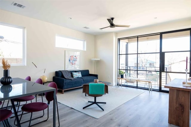 living room featuring ceiling fan, plenty of natural light, and hardwood / wood-style flooring