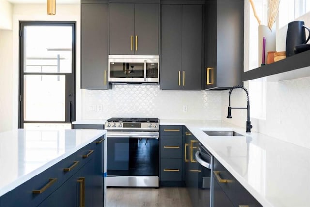 kitchen featuring appliances with stainless steel finishes, tasteful backsplash, dark wood-type flooring, and sink