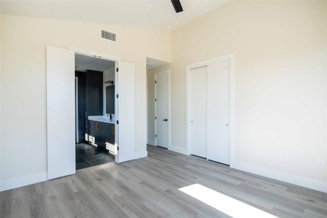 unfurnished bedroom featuring ceiling fan, a closet, vaulted ceiling, and light wood-type flooring