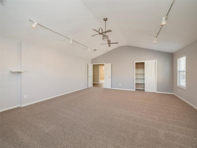 carpeted empty room featuring lofted ceiling, ceiling fan, and track lighting