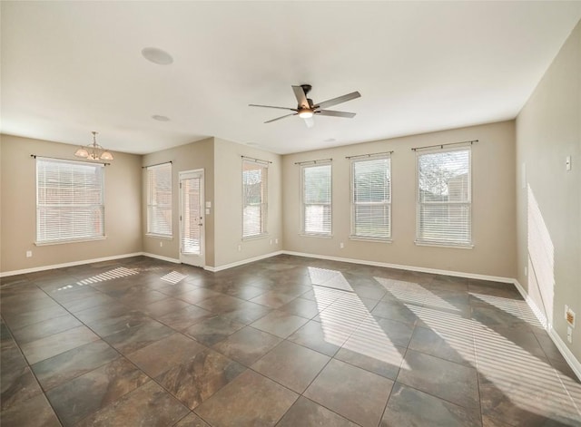 spare room with ceiling fan with notable chandelier