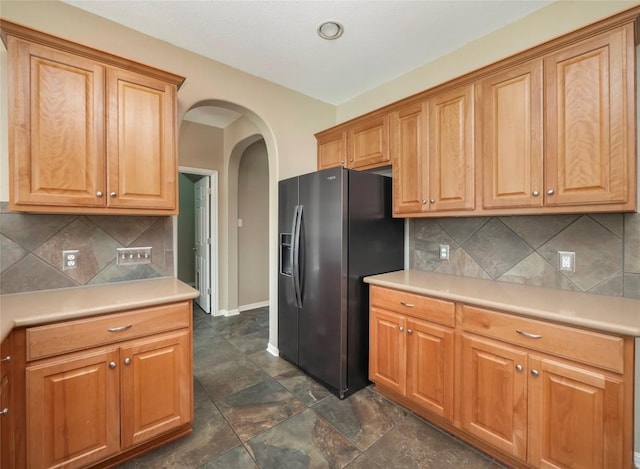 kitchen featuring tasteful backsplash and fridge with ice dispenser