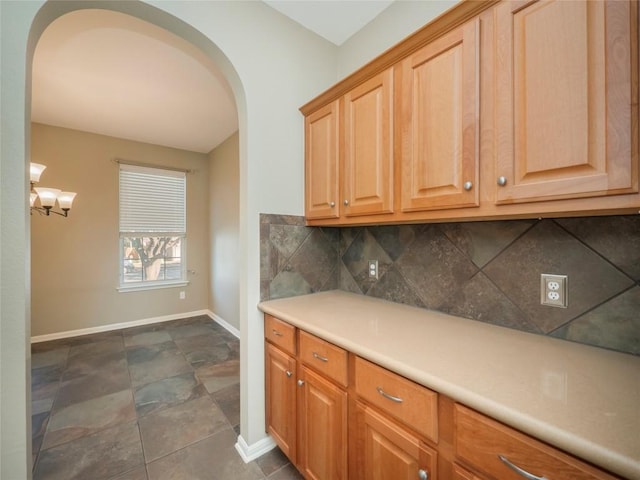 kitchen featuring tasteful backsplash and a chandelier