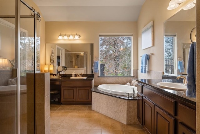 bathroom with independent shower and bath, lofted ceiling, a wealth of natural light, and tile patterned floors