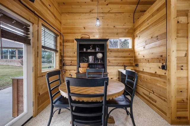 dining room featuring lofted ceiling, wood walls, and wooden ceiling