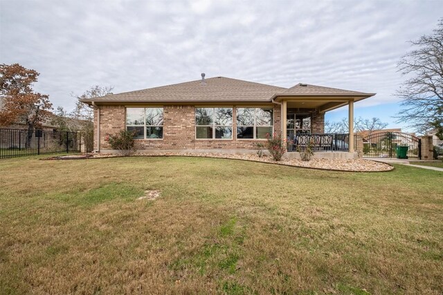 rear view of house featuring a lawn