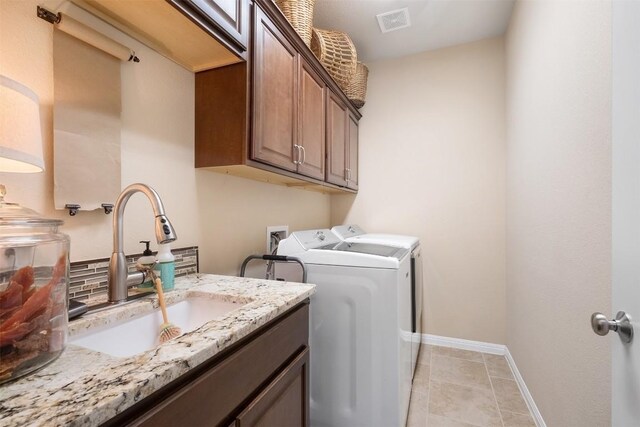 washroom featuring sink, light tile patterned flooring, cabinets, and independent washer and dryer