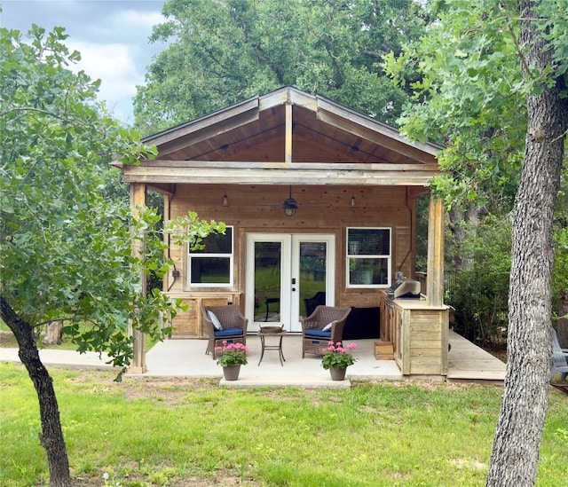 back of property with a lawn and french doors