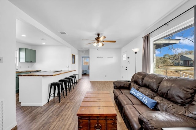 living room with dark hardwood / wood-style flooring and ceiling fan