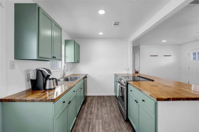 kitchen featuring wooden counters, sink, green cabinetry, hardwood / wood-style flooring, and stainless steel appliances