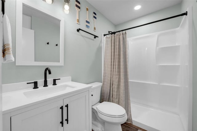 bathroom with a shower with shower curtain, vanity, and toilet