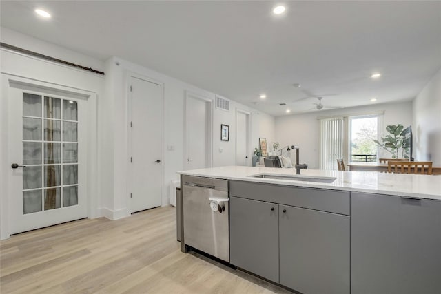 kitchen featuring stainless steel dishwasher, light hardwood / wood-style floors, ceiling fan, sink, and gray cabinets