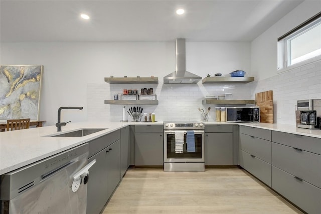 kitchen with sink, stainless steel appliances, backsplash, and wall chimney range hood