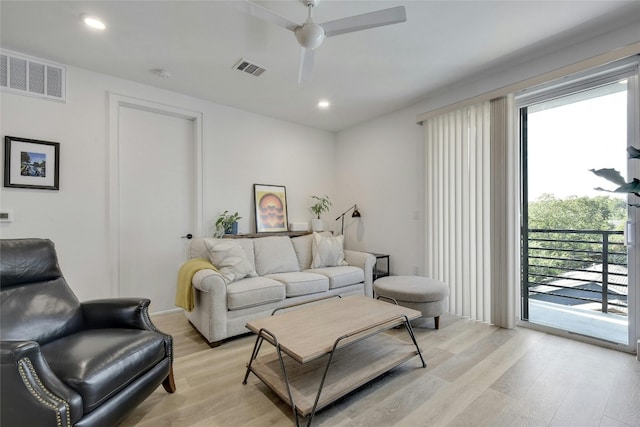 living room with ceiling fan and light hardwood / wood-style flooring