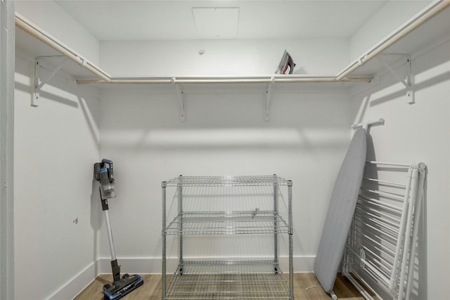 walk in closet with light hardwood / wood-style floors