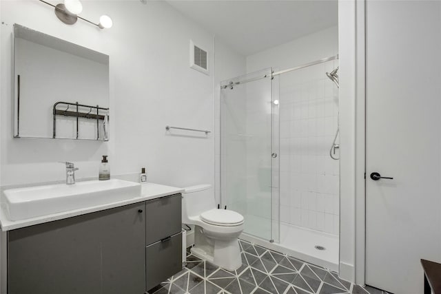 bathroom with tile patterned floors, vanity, toilet, and a shower with door