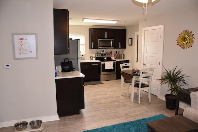 kitchen featuring dark brown cabinets, stainless steel appliances, and light hardwood / wood-style floors