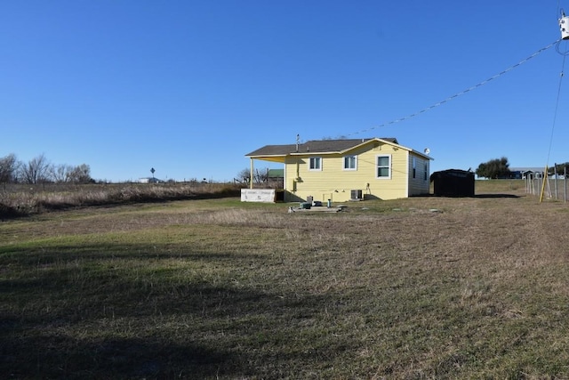 rear view of property featuring a yard and central air condition unit