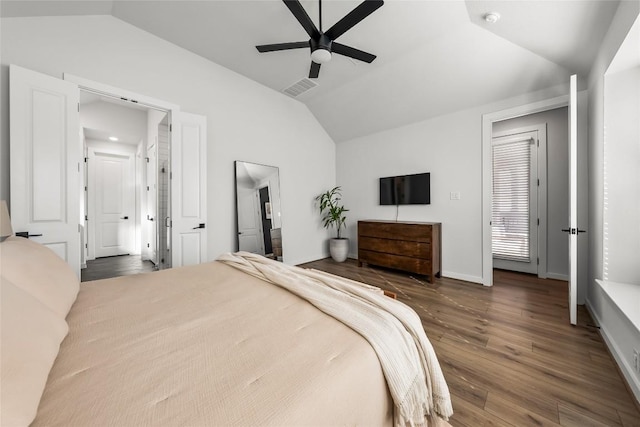 bedroom with ceiling fan, dark wood-type flooring, and vaulted ceiling