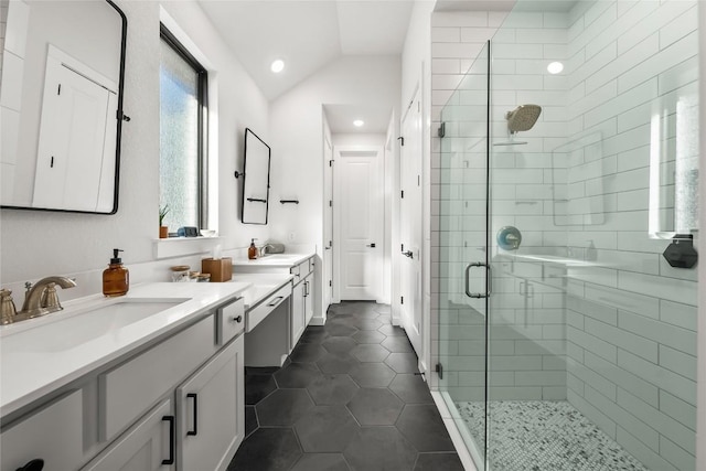 bathroom featuring tile patterned flooring, vanity, a shower with shower door, and vaulted ceiling