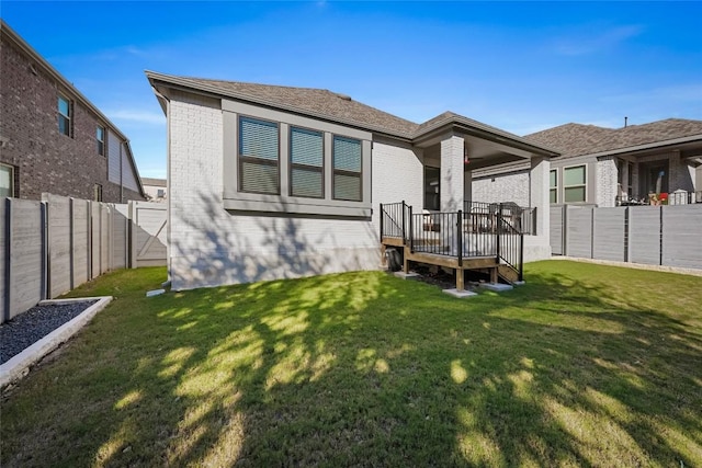 back of house with a lawn and a deck