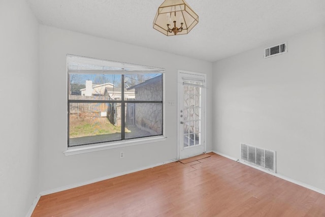 16046 Stoneham Cir, Pflugerville, TX 78660 - unfurnished room with wood finished floors, baseboards, and a chandelier