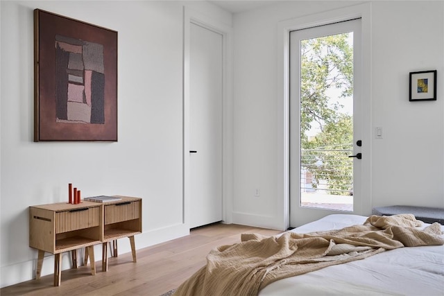 bedroom with access to exterior and light wood-type flooring