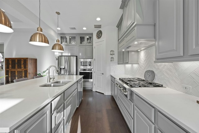 kitchen featuring decorative backsplash, stainless steel appliances, sink, pendant lighting, and gray cabinets