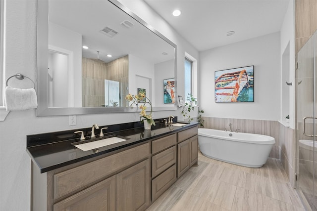 bathroom featuring shower with separate bathtub and vanity