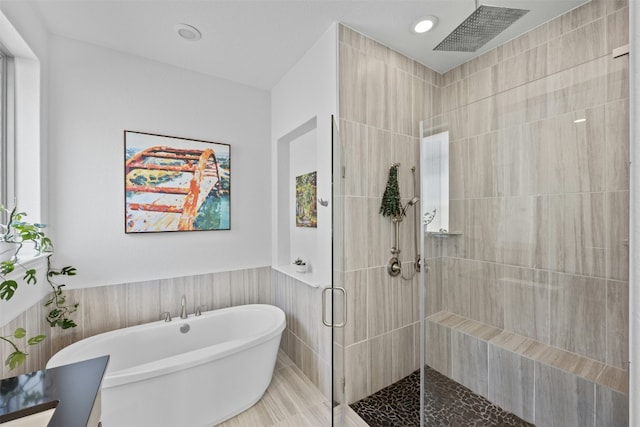 bathroom with tile walls and plus walk in shower