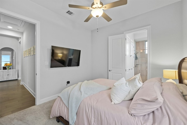 bedroom featuring dark hardwood / wood-style flooring, connected bathroom, and ceiling fan