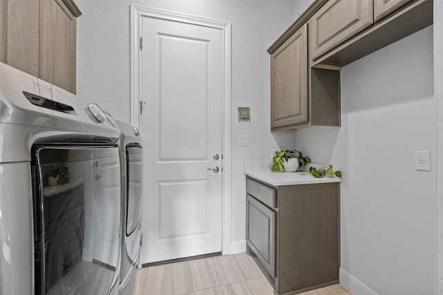 washroom featuring cabinets and washing machine and dryer