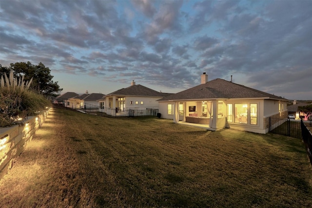 back house at dusk with a yard