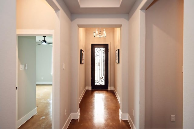 doorway to outside with ceiling fan with notable chandelier