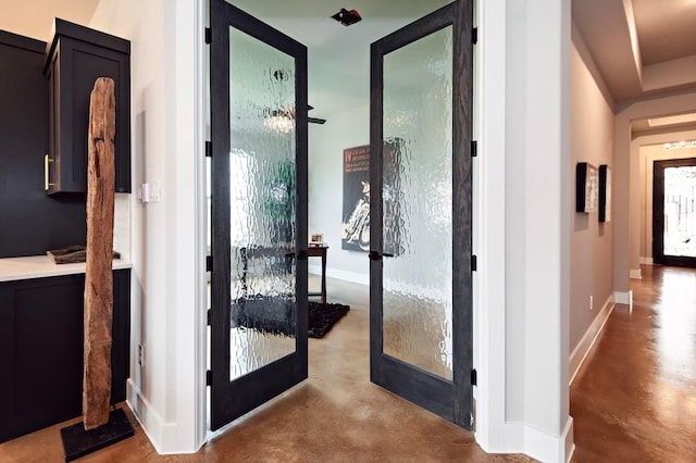 hall featuring concrete flooring and french doors