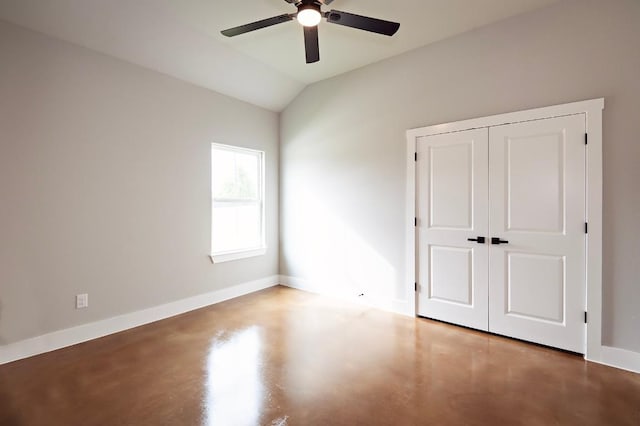 unfurnished bedroom with ceiling fan, a closet, concrete flooring, and lofted ceiling