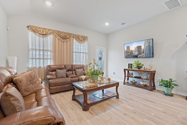 living room featuring light hardwood / wood-style floors and lofted ceiling