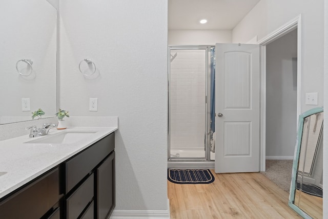 bathroom with vanity, hardwood / wood-style flooring, and a shower with shower door